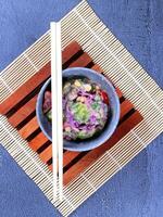 a bowl of food with chopsticks on top of a bamboo mat photo