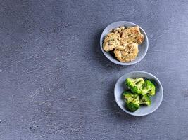 two plates of broccoli and a bowl of chicken photo