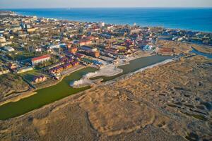 Aerial drone view of a township by the sea during sunset photo