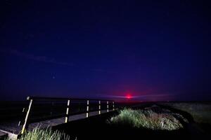 Nighttime Bridge with Distant Lighthouse westerhever photo