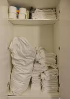 Organized Cabinet with White Linens and Towels photo