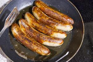 Golden-Brown Sausages Sizzling in a Frying Pan photo