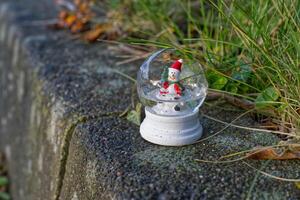 Snowman Snow Globe on Concrete with broken Grass photo
