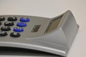 A calculator with solar cells and keys with the focus on the Euro sign against a grey background photo