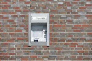 A German ATM is embedded in a wall of brown-red clinker bricks to withdraw money with EC Visa Mastercard credit card photo