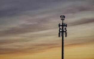 A radio tower for LTE UMTS and mobile internet in Hamburg at sunset against a golden backdrop photo