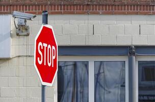 In Flensburg Harbor a surveillance camera is mounted on a building, in front of which is a STOP sign photo