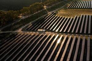 Rows of solar panels stretching across the landscape on sunny day photo