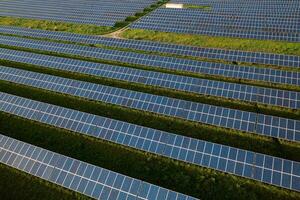 Solar farm with rows of panels on field photo