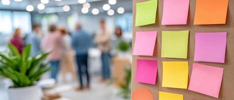 Inclusive workplace culture is shown with colorful sticky notes on board and blurred people collaborating in bright modern office space photo