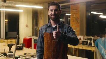 feliz positivo caucasiano homem madeira mestre demonstrando polegar acima gesto dentro oficina cara artesão mostrando aprovar masculino artista carpinteiro apoiando símbolo super reação construtor sorridente recomendação video