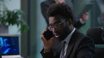 deux la diversité Hommes africain américain caucasien mâles les mecs les hommes d'affaires résolution affaires problèmes parlant mobile téléphone appel centre service d'assistance les opérateurs collègues de travail Bureau professionnel équipe soutien les clients video