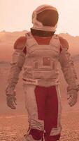 3d rendering. Astronaut walking on Mars red desert landscape. Space exploration mission concept mountains under orange sky atmosphere. video