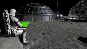 3d rendering. Astronaut on the moon typing on a laptop with a green screen. video