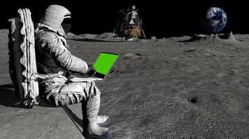 3d Rendering. Astronaut on the moon typing on laptop with a green screen. video