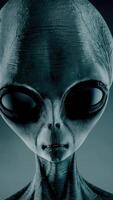 3D rendering. Portrait of Scary gray alien stands and looks blinking on a dark smoky background. UFO futuristic concept. video