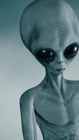 3D rendering. Scary gray alien stands and looks blinking on a dark smoky background. Threatening gesture. video