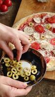 Vertical . Making pizza with olives, mushrooms and tomatoes. video