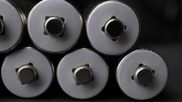 Close-Up View of Rechargeable Batteries Lined Up in Dark Environment Highlighting Charging Process video