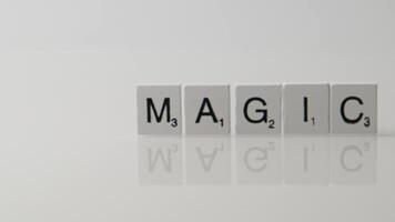 Creative Close-Up of Scrabble Tiles Spelling Magic on a Clean White Reflective Surface video