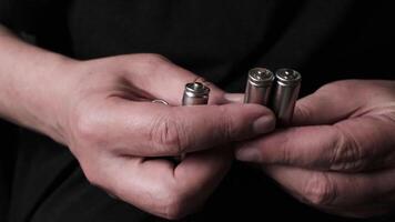 Close-up of hands holding rechargeable batteries in a dark environment highlighting energy storage concept video