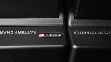 Close-up View of Battery Chargers with Red Indicator Lights in a Dark Environment Highlighting Charging Process video