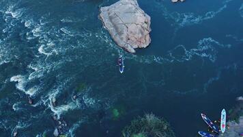 A top-down aerial view of rowers on kayak docking to the shore. video