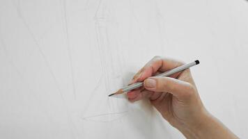 Hand sketching with pencil on white canvas. Close-up of an artists hand drawing precise lines with a pencil on a blank canvas, beginning an artwork or technical video