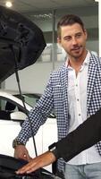 Enthusiastic salesman highlights car engine features to intrigued buyer video