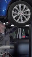 Focused young mechanic diagnosing vehicle issues in a bustling garage video