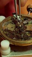 Watchmaker skillfully places cogwheel into intricate repeater mechanism video