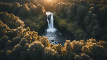 Waterfall Flowing Through Forest Captured From Above at Sunset photo