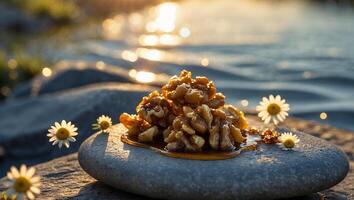 Walnut Pile with Honey Drizzle on Stone with Gentle Water Backdrop photo