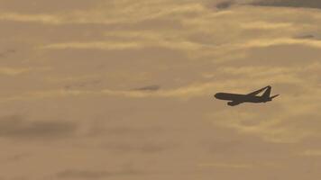 Jet airliner flying in the cloudy sunset sky. Perfect for themes of travel, aviation, freedom, and adventure video