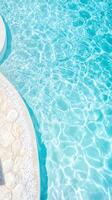 Sparkling blue pool water ripples gently, reflecting sunlight and creating a tranquil atmosphere for relaxation and recreation. photo