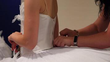 Hands sewing and adjusting a white tutu backstage before ballet performance video