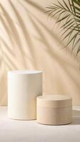 Beige cylindrical display stands with palm leaf shadows photo