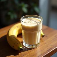 Banana Smoothie in Glass with Banana on Wooden Table photo