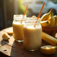 Preparing Banana Smoothie Drinks with Wooden Straws on Wooden Table photo