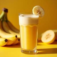 Pouring Fresh Banana Smoothie Drink in Glass with Banana Slice Garnish photo