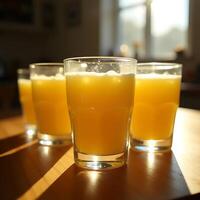 Serving Orange Juice in Glass Cups on Wooden Table in Sunlight photo