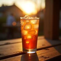 Iced Drink on Wooden Table at Sunset Refreshing Beverage photo