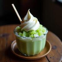 Dessert Glass with Green Melon Cubes and Whipped Cream Topping photo