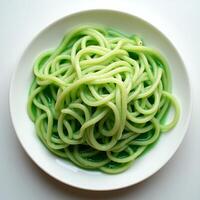 Serving of Green Colored Noodles on White Plate Top View photo