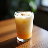 Refreshing Layered Drink in Glass on Wooden Table in Sunlight photo