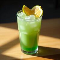 Refreshing Green Drink with Lemon and Ice on Sunny Table photo