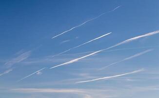Contrails - a flying transport airplanes with condensation trails in the a sky photo