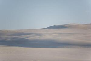 A person standing on top of a hill in the middle of a desert photo