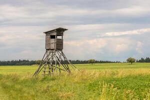 hunting blind on a field, in the background the sky with white clouds photo