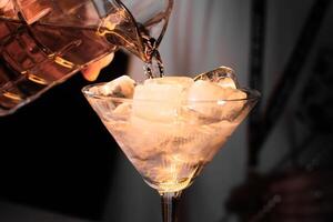 a person pours a drink into a glass photo